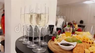 自助餐桌上有香槟和水果的酒杯，餐厅或酒店大堂的自助餐桌，摄像机